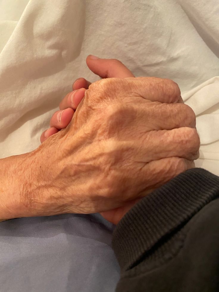 A young hand holding an older one.
